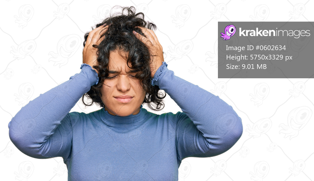 Young hispanic woman with curly hair wearing casual clothes suffering from headache desperate and stressed because pain and migraine. hands on head. 