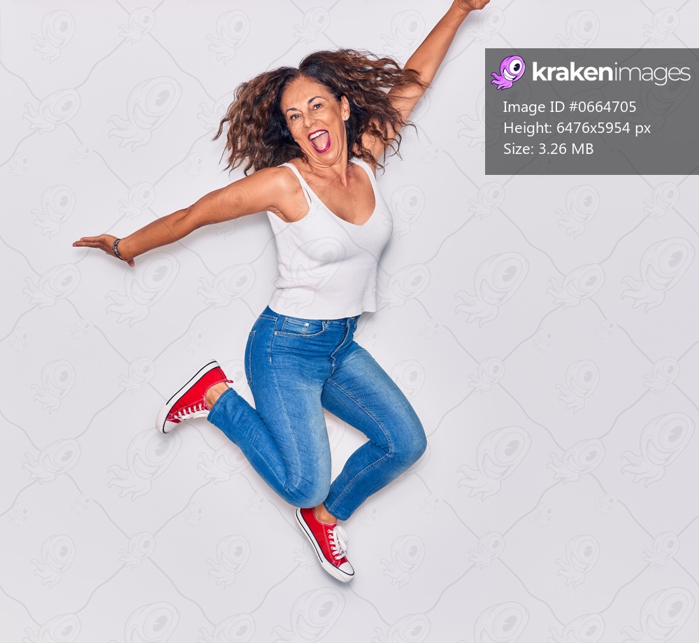 Middle age beautiful hispanic woman wearing casual clothes smiling happy. Jumping with smile on face over isolated white background