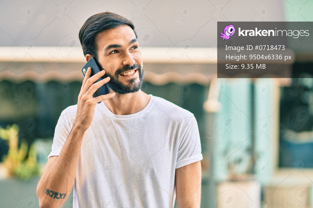 Young hispanic man smiling happy talking on the smartphone at the city.
