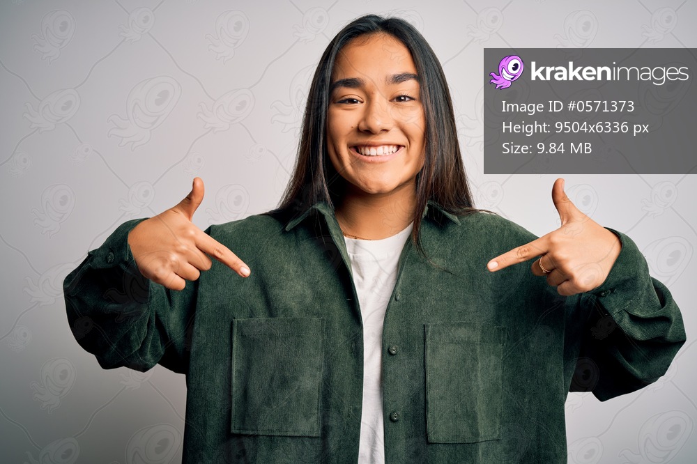 Young beautiful asian woman wearing casual shirt standing over isolated white background looking confident with smile on face, pointing oneself with fingers proud and happy.
