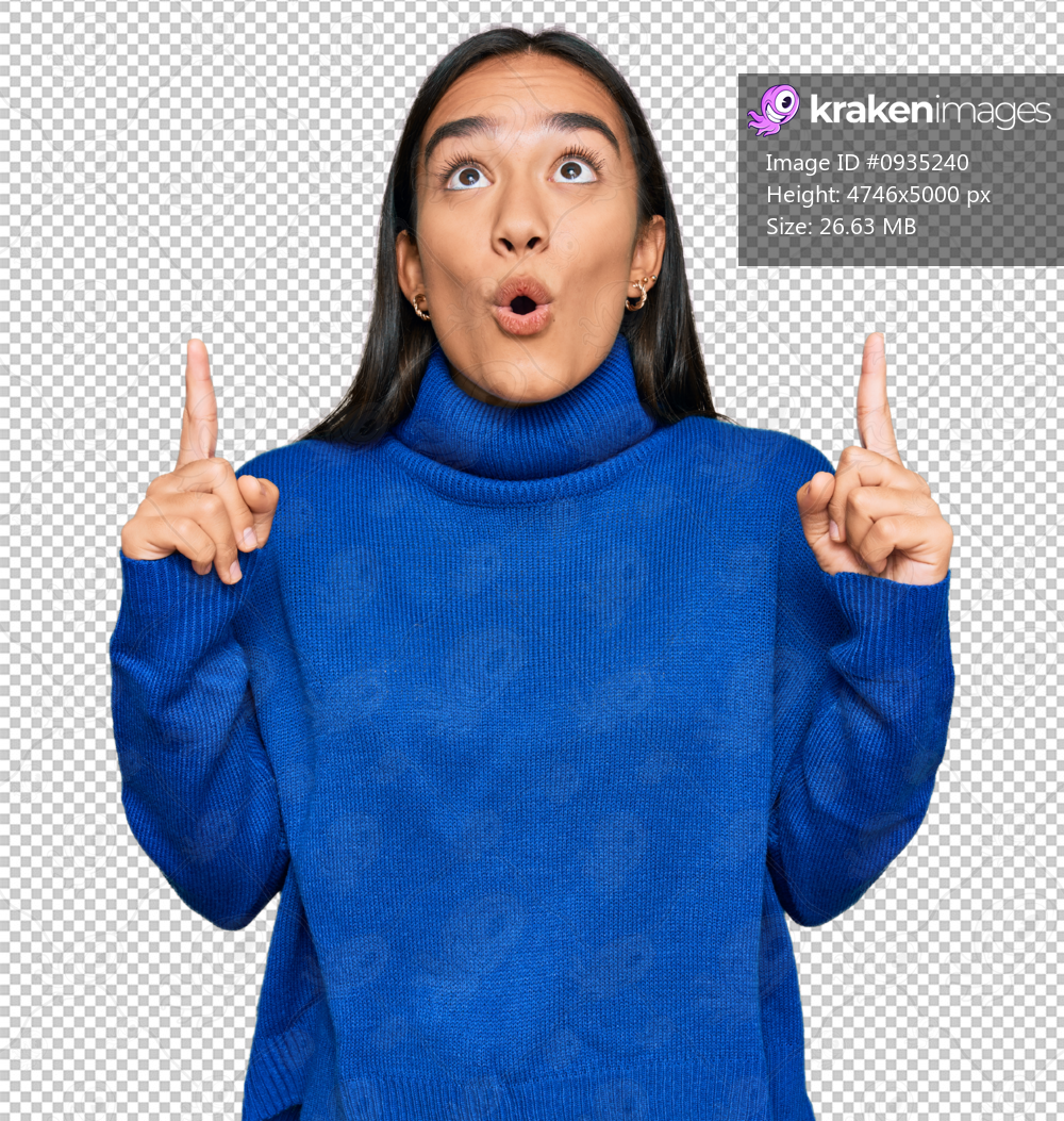 Young asian woman wearing casual winter sweater amazed and surprised looking up and pointing with fingers and raised arms.