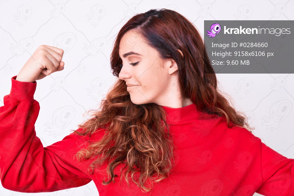 Young beautiful woman wearing casual clothes showing arms muscles smiling proud. fitness concept. 