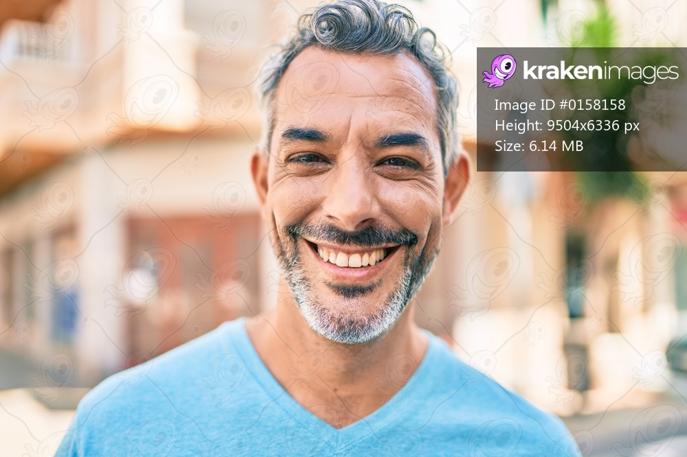 Middle age grey-haired man smiling happy walking at street of city.