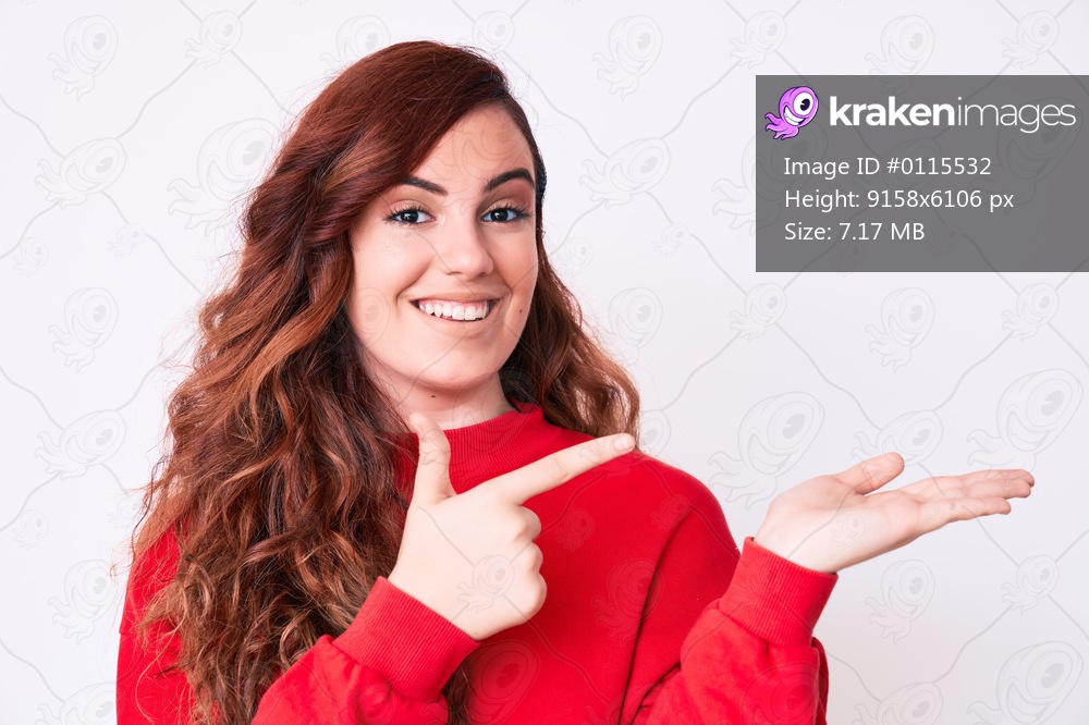 Young beautiful woman wearing casual clothes amazed and smiling to the camera while presenting with hand and pointing with finger. 