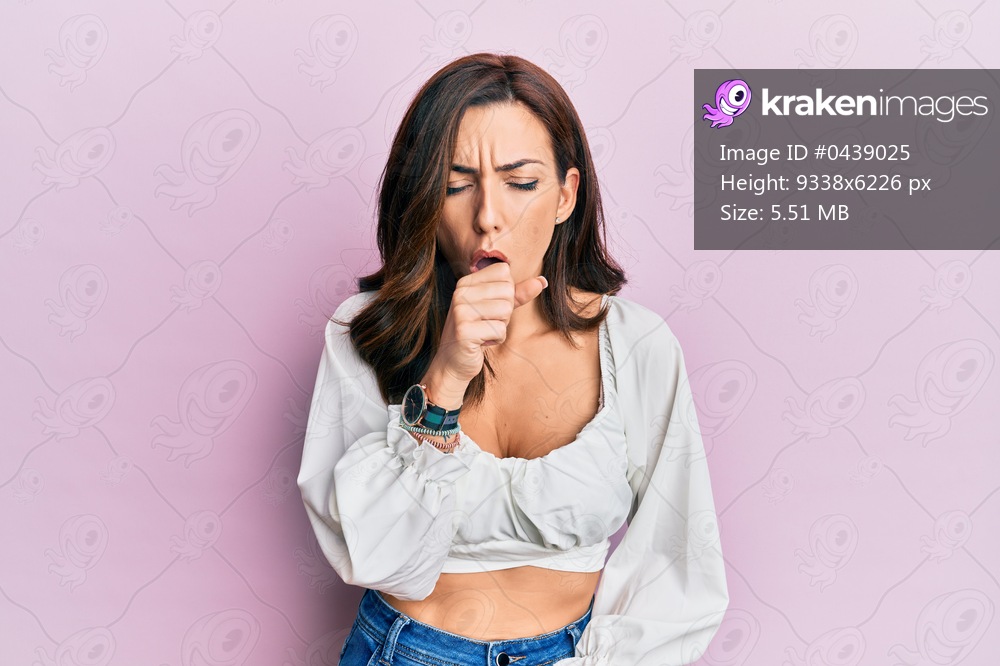 Young brunette woman wearing casual clothes over pink feeling unwell and coughing as symptom for cold or bronchitis. health care concept. 