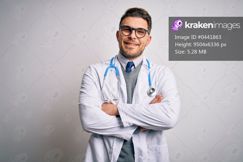 Young doctor man with blue eyes wearing medical coat and stethoscope over isolated background happy face smiling with crossed arms looking at the camera. Positive person.