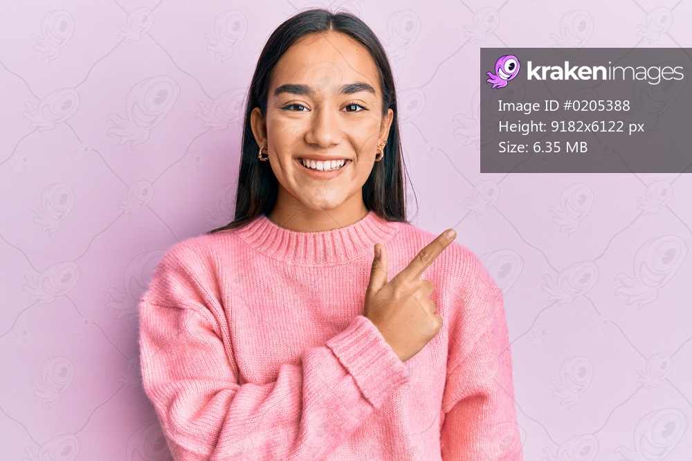 Young asian woman wearing casual winter sweater smiling cheerful pointing with hand and finger up to the side 