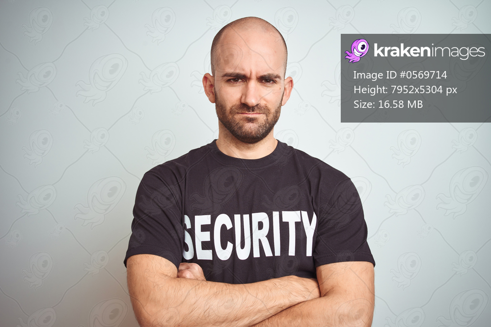 Young safeguard man wearing security uniform over isolated background skeptic and nervous, disapproving expression on face with crossed arms. Negative person.