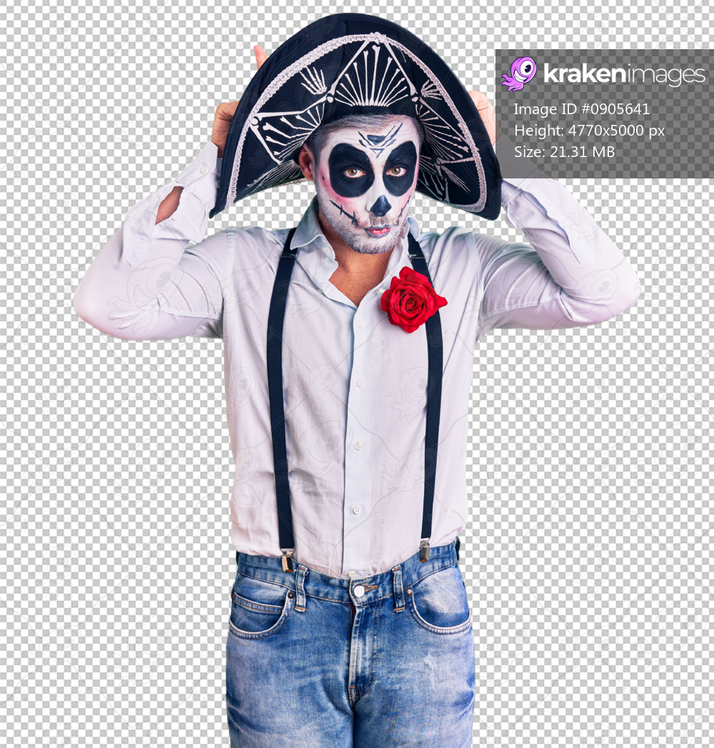 Man wearing day of the dead costume over background doing funny gesture with finger over head as bull horns