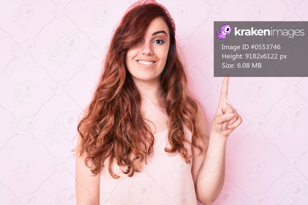 Young beautiful woman wearing casual clothes showing and pointing up with finger number one while smiling confident and happy. 