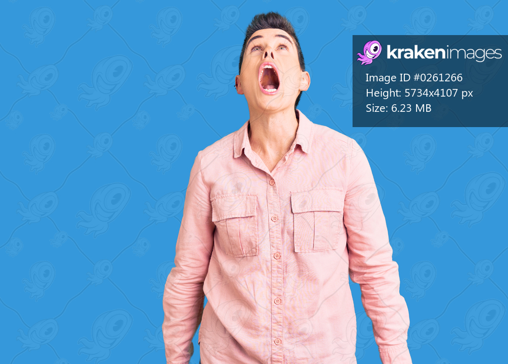 Young woman with short hair wearing casual clothes angry and mad screaming frustrated and furious, shouting with anger. rage and aggressive concept. 