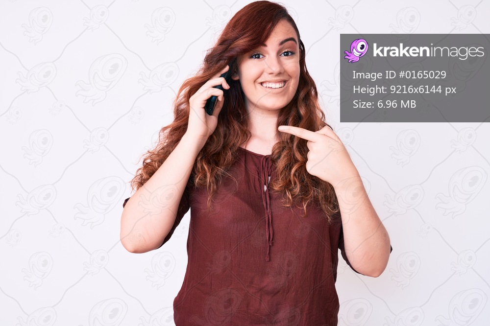 Young beautiful woman having conversation talking on the smartphone smiling happy pointing with hand and finger 