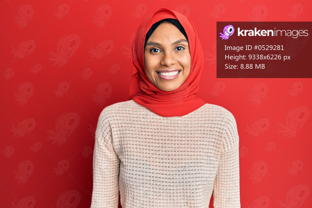 Young african american woman wearing traditional islamic hijab scarf with a happy and cool smile on face. lucky person. 