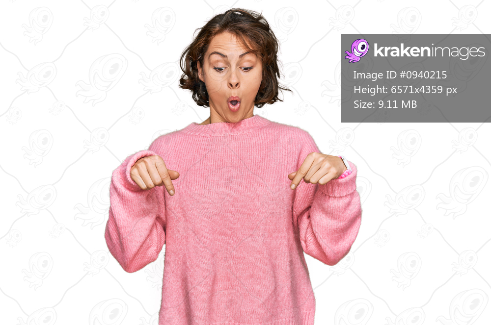Young hispanic woman wearing casual clothes pointing down with fingers showing advertisement, surprised face and open mouth 