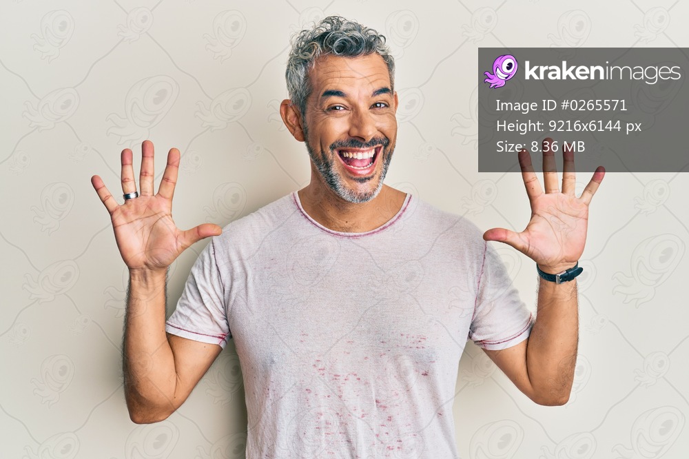 Middle age grey-haired man wearing casual clothes showing and pointing up with fingers number ten while smiling confident and happy. 