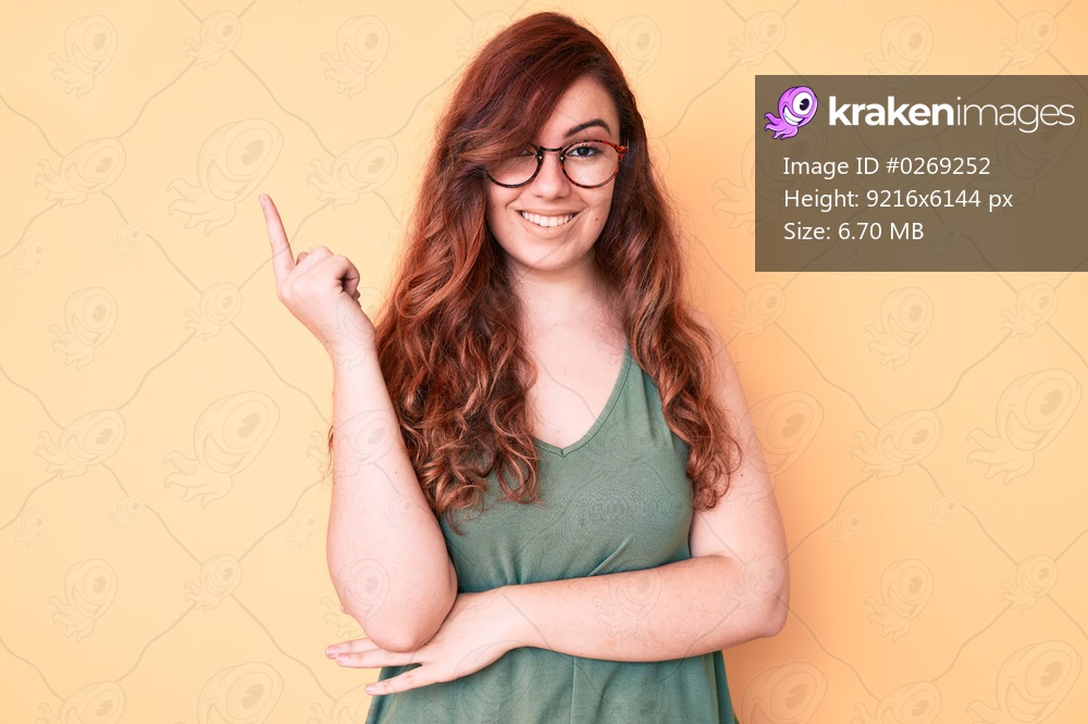 Young beautiful woman wearing casual clothes and glasses smiling happy pointing with hand and finger to the side 