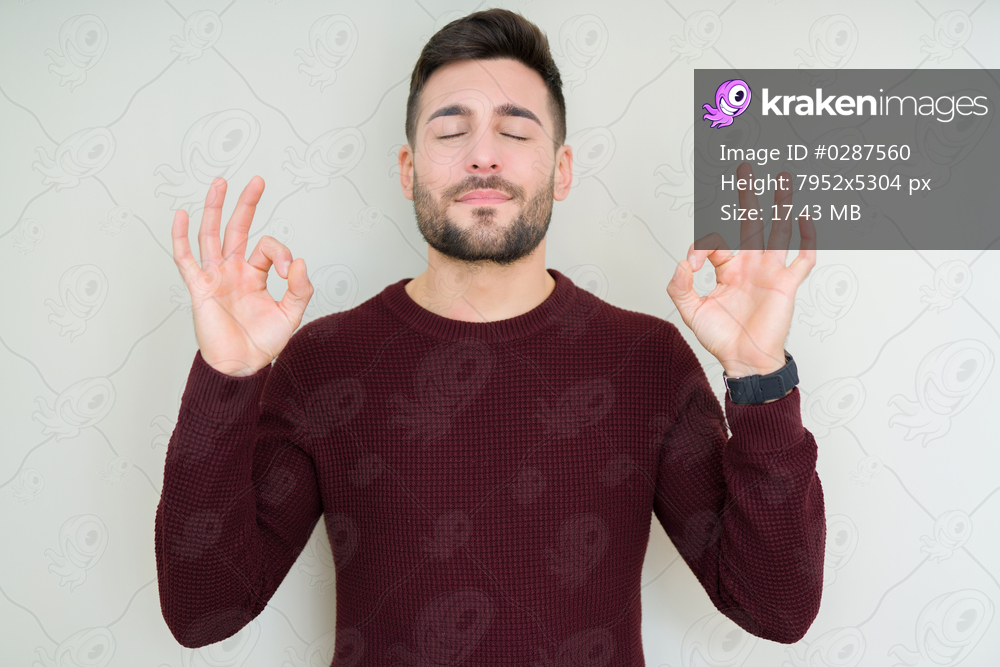 Young handsome man wearing a sweater over isolated background relax and smiling with eyes closed doing meditation gesture with fingers. Yoga concept.