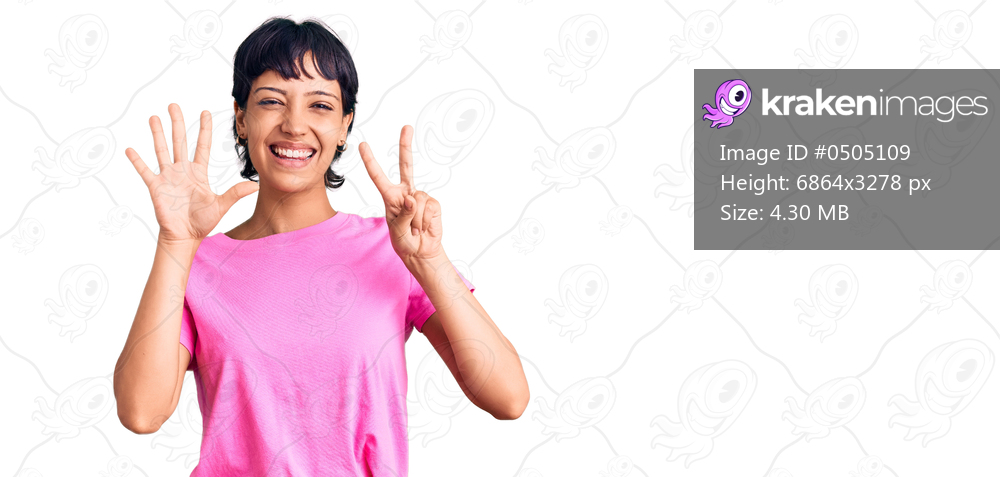 Young brunette woman with short hair wearing casual clothes showing and pointing up with fingers number seven while smiling confident and happy. 