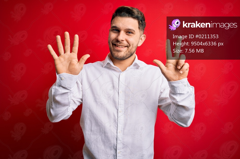 Young business man with blue eyes wearing elegant shirt standing over red isolated background showing and pointing up with fingers number eight while smiling confident and happy.