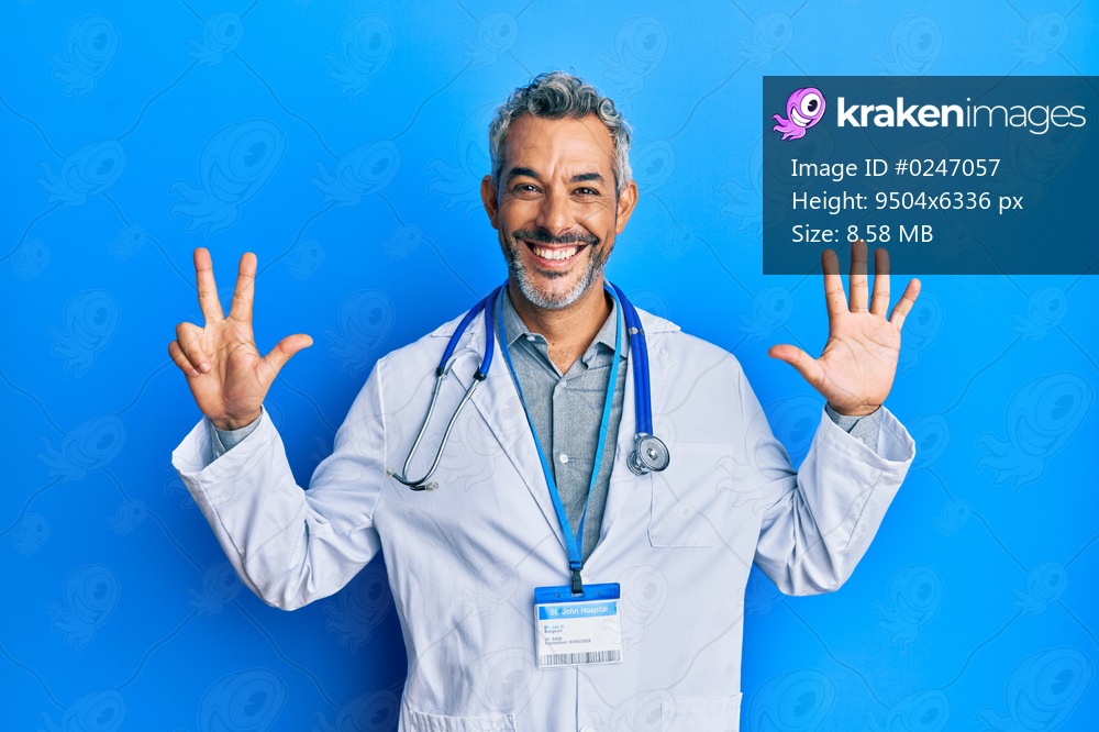 Middle age grey-haired man wearing doctor uniform and stethoscope showing and pointing up with fingers number eight while smiling confident and happy. 