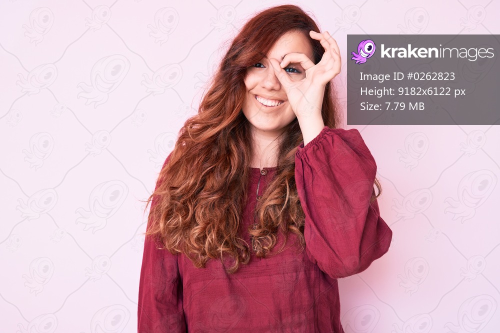 Young beautiful woman wearing casual winter sweater smiling happy doing ok sign with hand on eye looking through fingers 