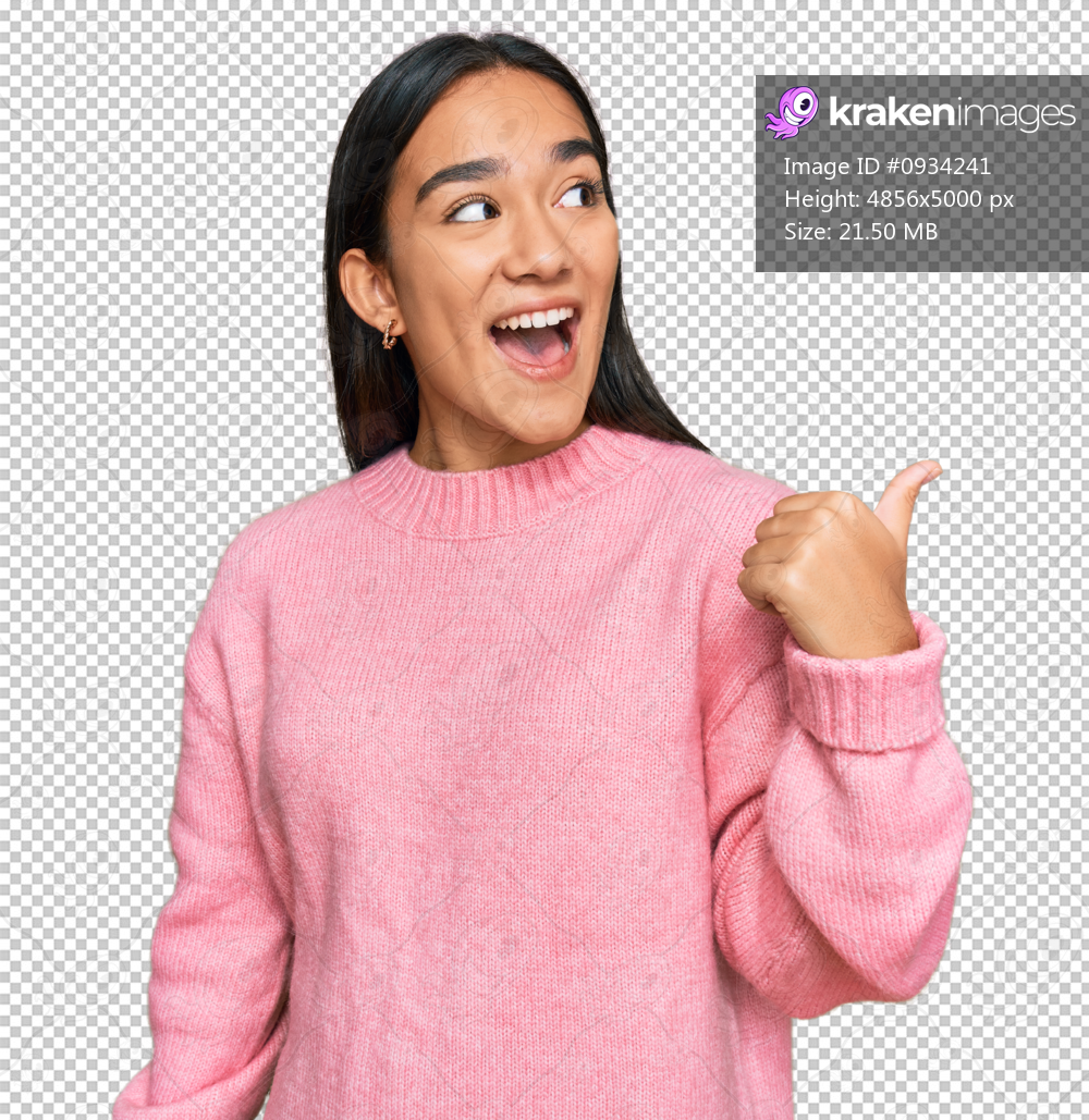 Young asian woman wearing casual winter sweater smiling with happy face looking and pointing to the side with thumb up.