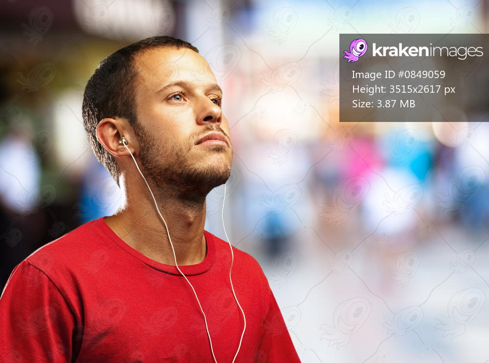young man listening to music against a city background