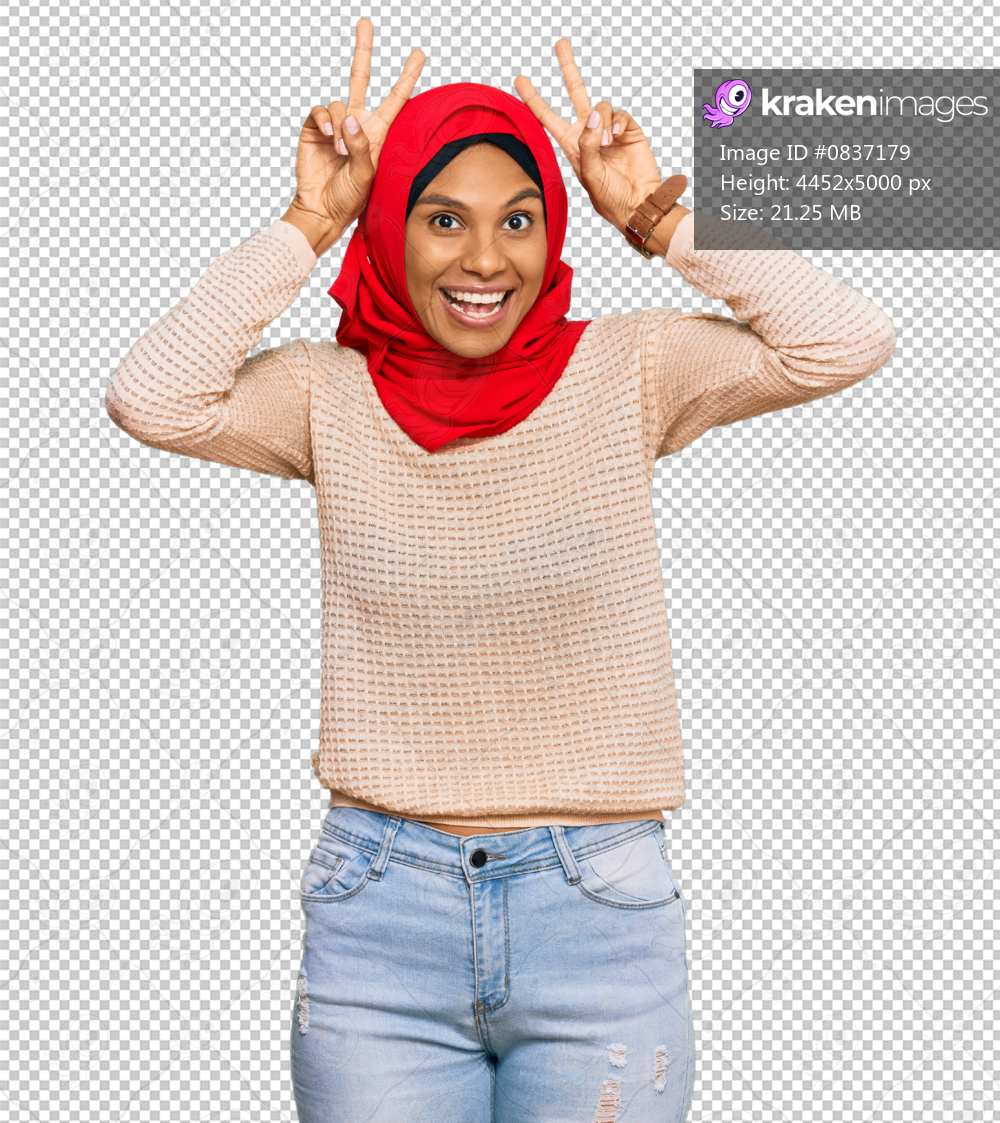 Young african american woman wearing traditional islamic hijab scarf posing funny and crazy with fingers on head as bunny ears, smiling cheerful