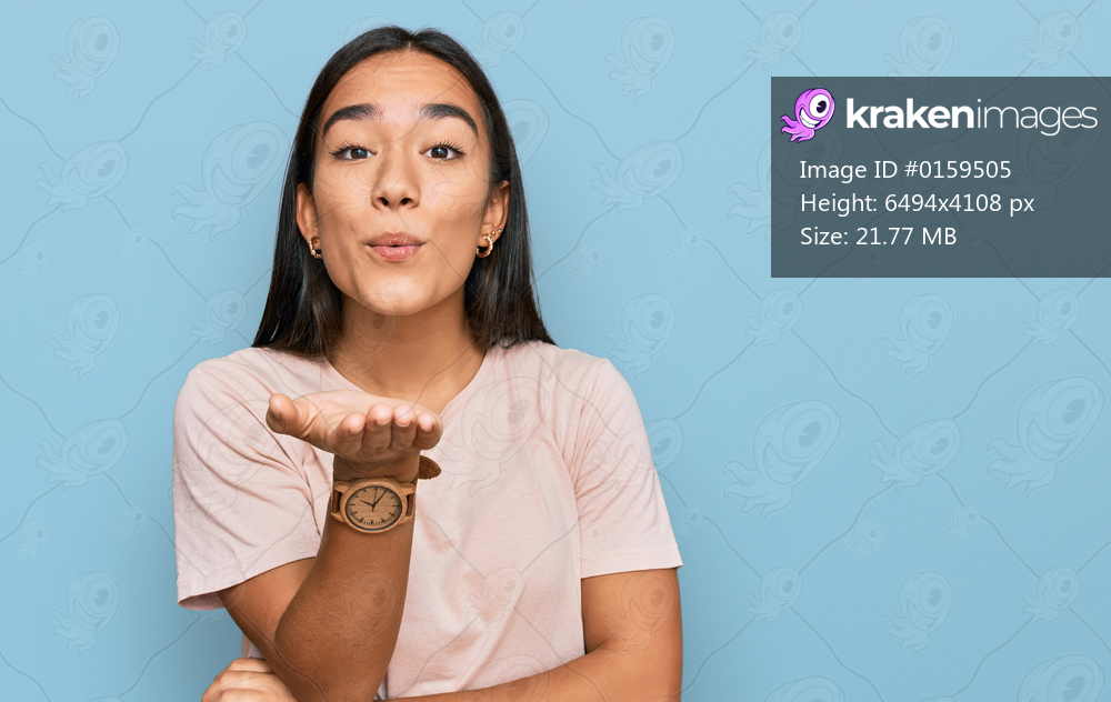 Young asian woman wearing casual clothes looking at the camera blowing a kiss with hand on air being lovely and sexy. love expression. 