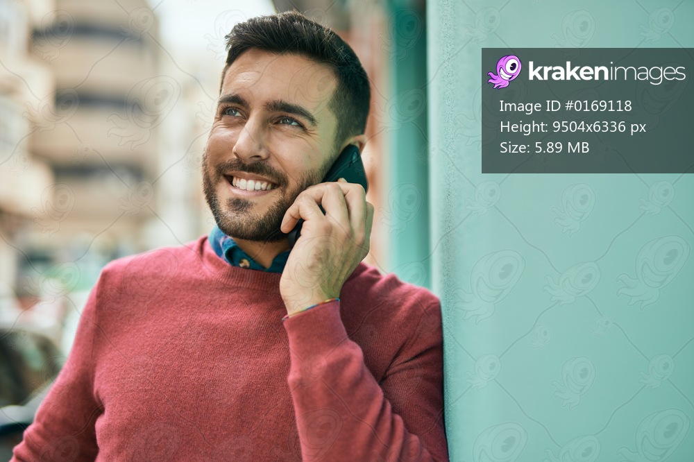 Young hispanic man smiling happy talking on the smartphone at the city.