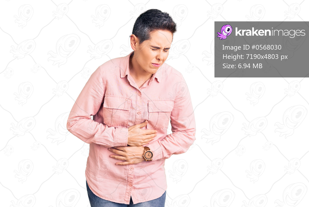 Young woman with short hair wearing casual clothes with hand on stomach because indigestion, painful illness feeling unwell. ache concept. 