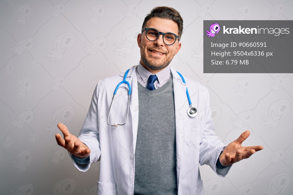 Young doctor man with blue eyes wearing medical coat and stethoscope over isolated background smiling cheerful with open arms as friendly welcome, positive and confident greetings