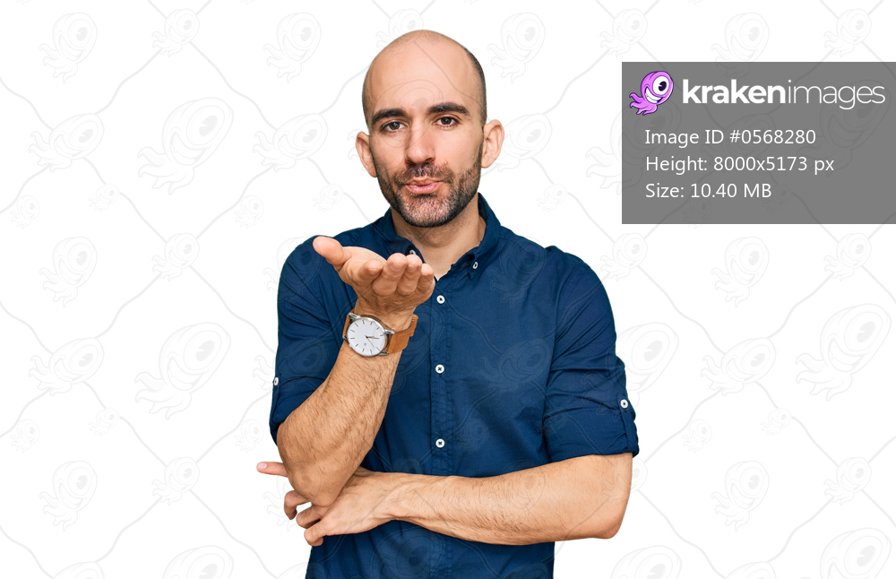 Young hispanic man wearing casual clothes looking at the camera blowing a kiss with hand on air being lovely and sexy. love expression. 