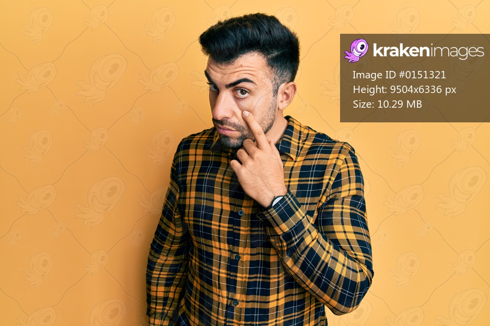 Young hispanic man wearing casual clothes pointing to the eye watching you gesture, suspicious expression 