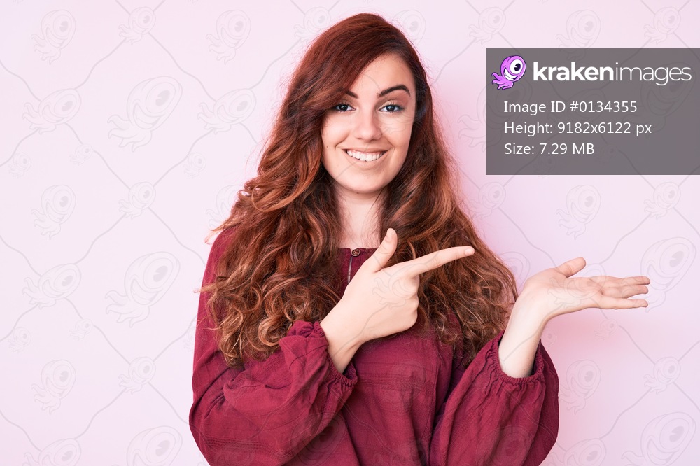 Young beautiful woman wearing casual winter sweater amazed and smiling to the camera while presenting with hand and pointing with finger. 