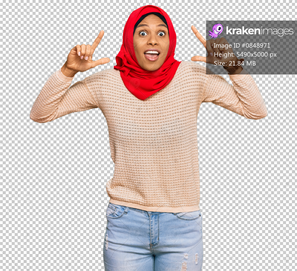 Young african american woman wearing traditional islamic hijab scarf smiling amazed and surprised and pointing up with fingers and raised arms.