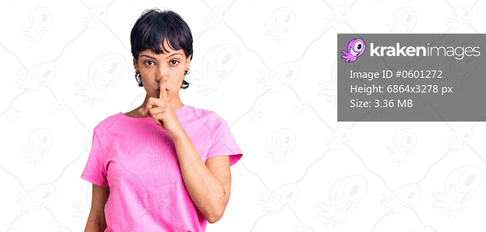 Young brunette woman with short hair wearing casual clothes asking to be quiet with finger on lips. silence and secret concept. 