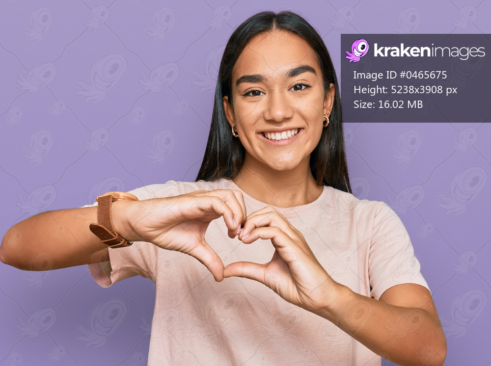 Young asian woman wearing casual clothes smiling in love doing heart symbol shape with hands. romantic concept. 