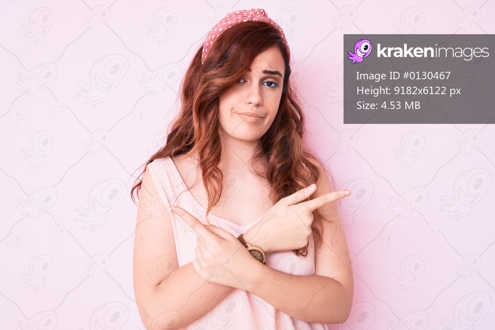 Young beautiful woman wearing casual clothes pointing to both sides with fingers, different direction disagree 