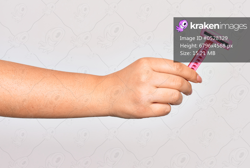 Hand of caucasian young woman holding pink razor over isolated white background