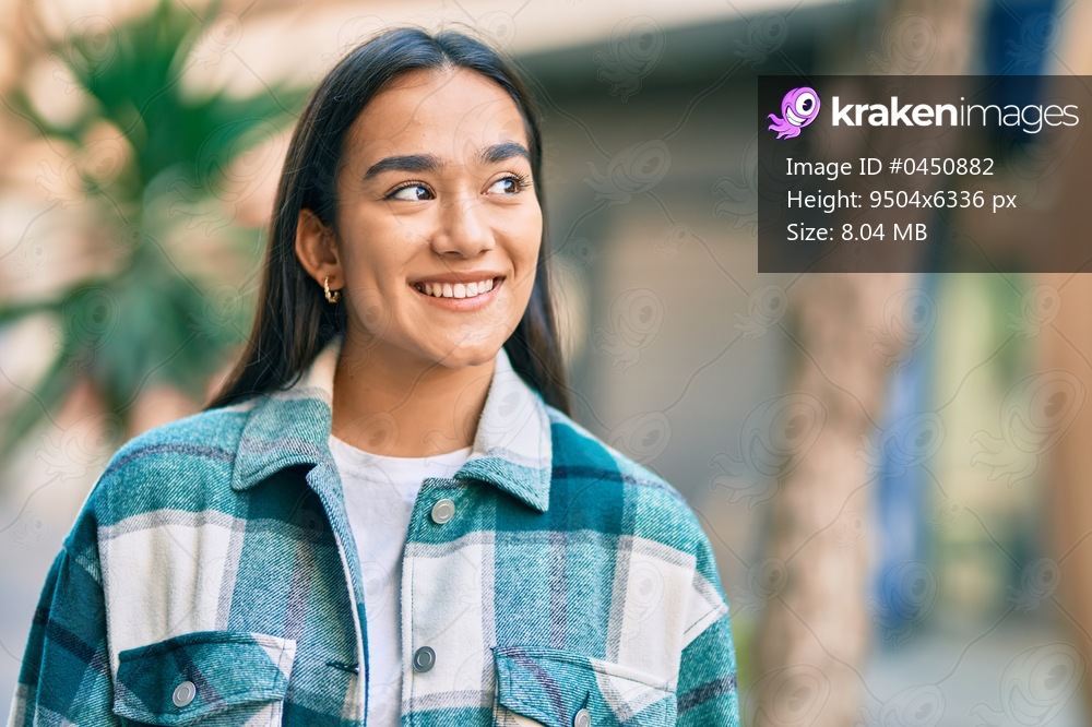 Young latin girl smiling happy standing at the city.