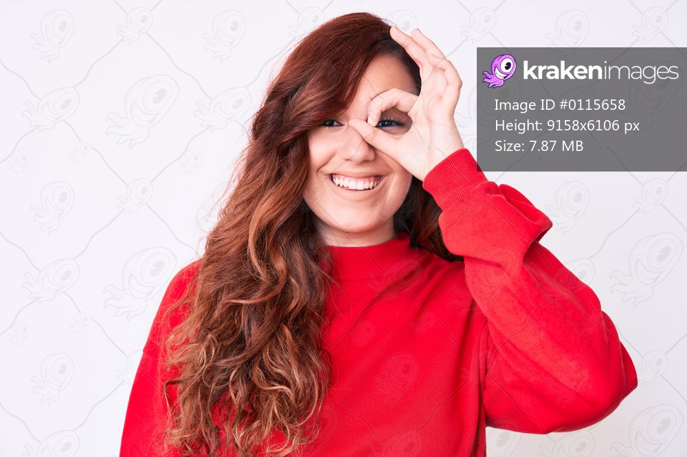 Young beautiful woman wearing casual clothes doing ok gesture with hand smiling, eye looking through fingers with happy face. 