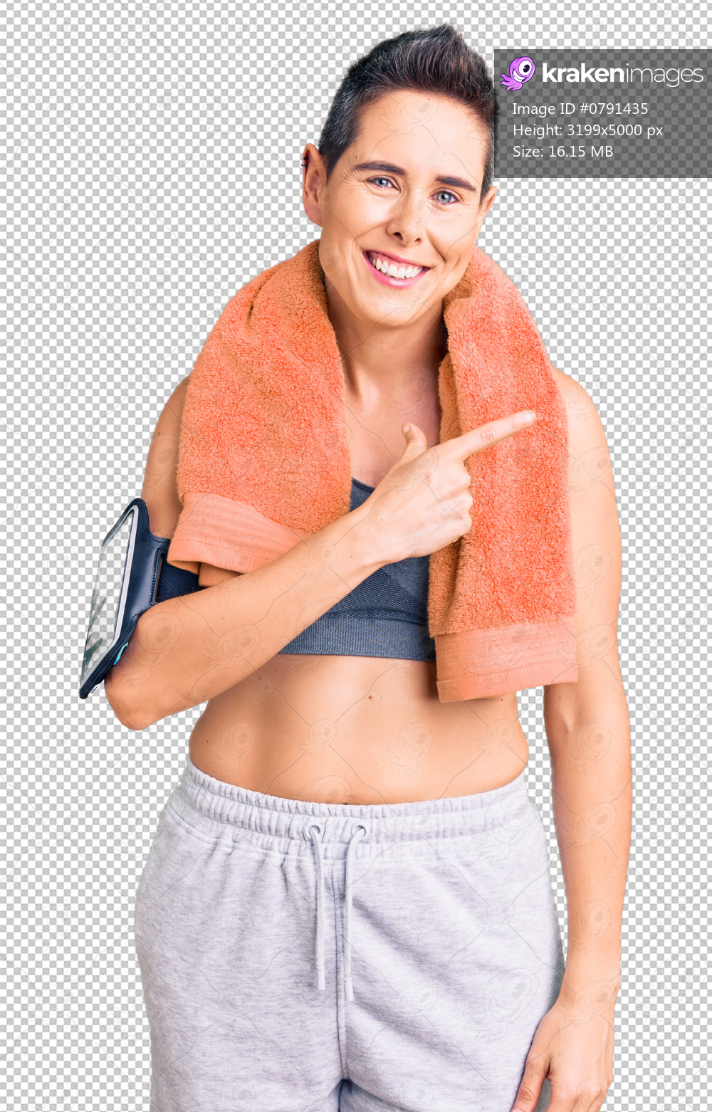 Young woman with short hair wearing sportswear and towel using smartphone cheerful with a smile of face pointing with hand and finger up to the side with happy and natural expression on face
