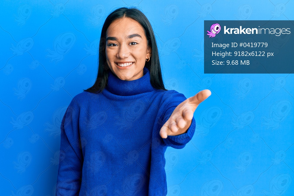 Young asian woman wearing casual winter sweater smiling cheerful offering palm hand giving assistance and acceptance. 