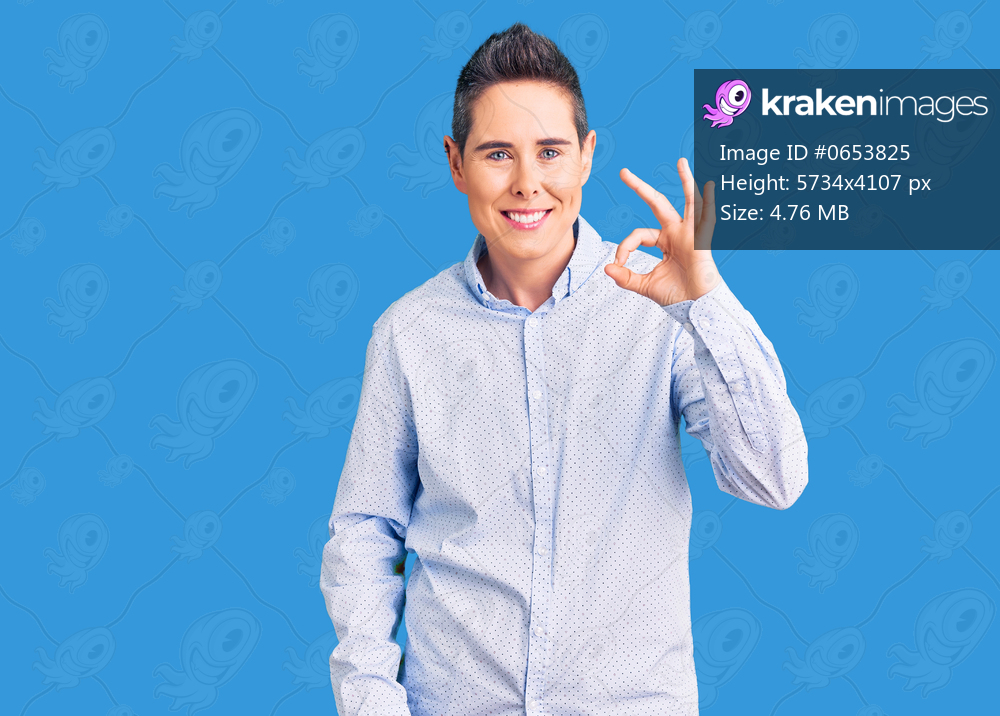 Young woman with short hair wearing business clothes smiling positive doing ok sign with hand and fingers. successful expression. 