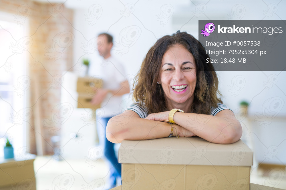 Middle age senior couple moving to a new house, woman smiling happy in love with new apartment