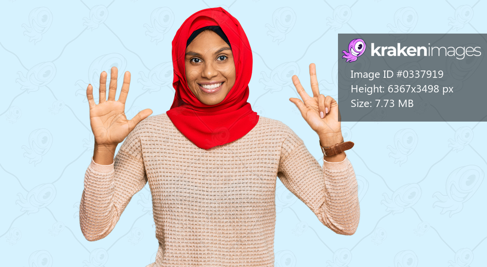 Young african american woman wearing traditional islamic hijab scarf showing and pointing up with fingers number eight while smiling confident and happy. 