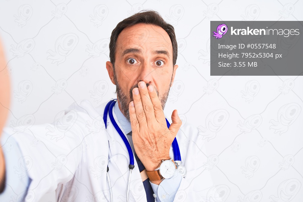 Middle age doctor man wearing stethoscope make selfie over isolated white background cover mouth with hand shocked with shame for mistake, expression of fear, scared in silence, secret concept