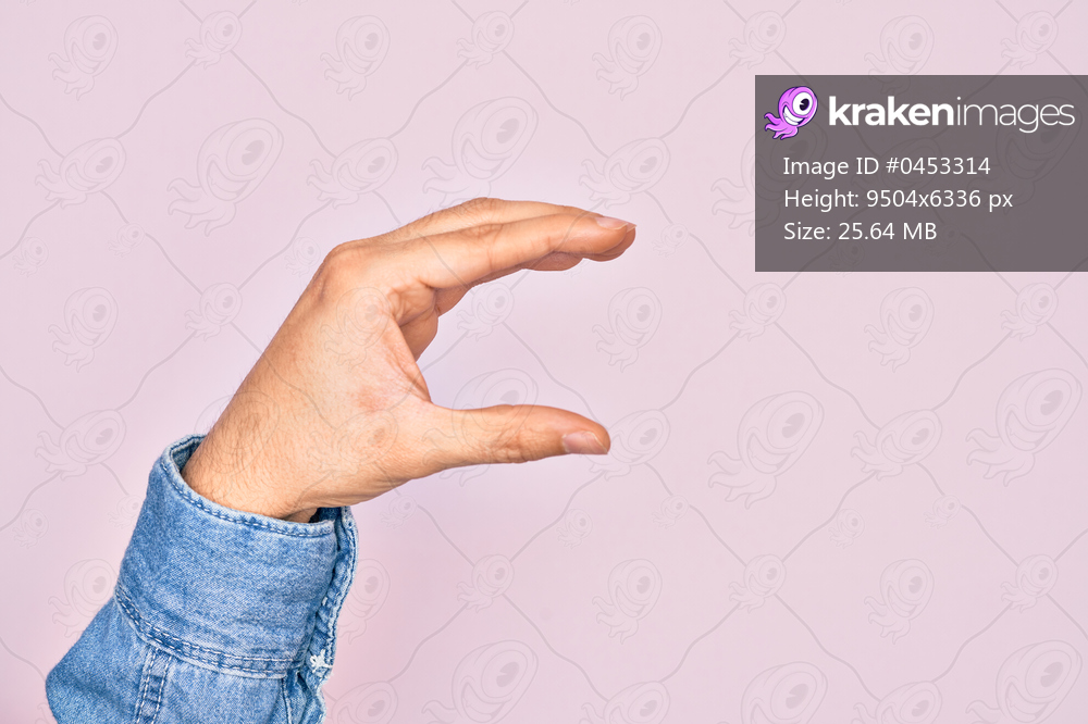 Hand of caucasian young man showing fingers over isolated pink background picking and taking invisible thing, holding object with fingers showing space
