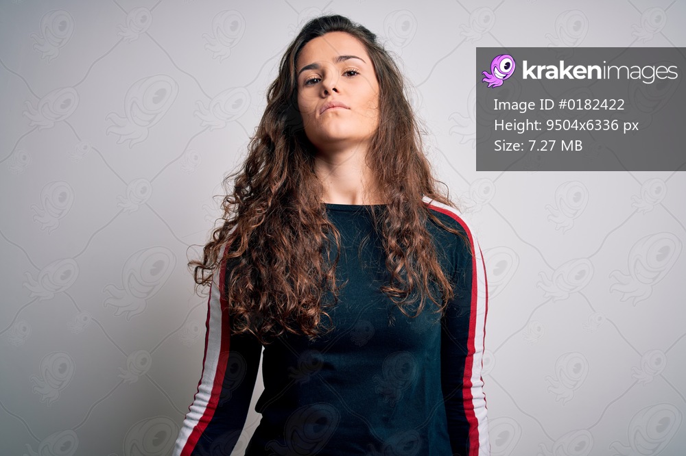 Young beautiful woman with curly hair wearing casual sweater over isolated white background Relaxed with serious expression on face. Simple and natural looking at the camera.